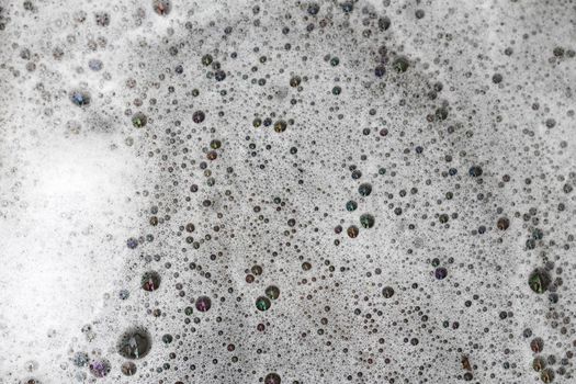 Detergent bubbles float in the waste water.