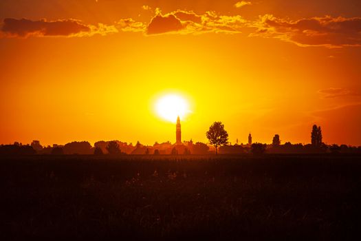 Sunset in a landscape with bell tower, trees and countryside