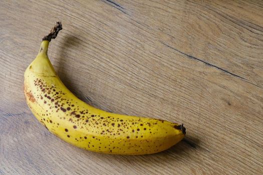 A yellow spotted banana lies on the table