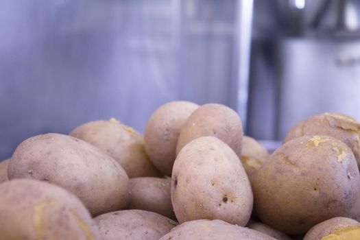 Boiled potatoes on restaurant kitchen table. No people