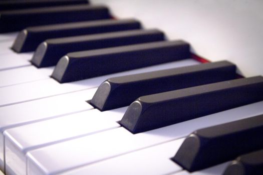 Part of the keyboard of a piano in white color. No people