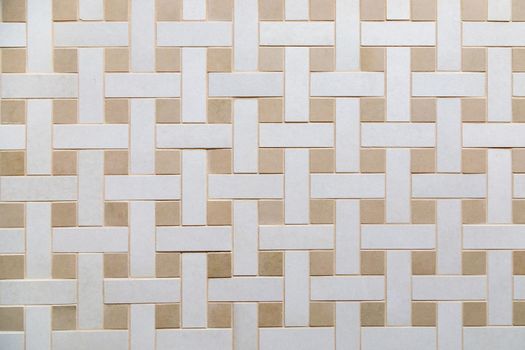 The texture of beige ceramic tiles with a weaving pattern. Construction material