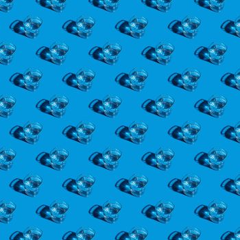 Seamless pattern of glasses with water on a blue background. For printing posters on fabric.