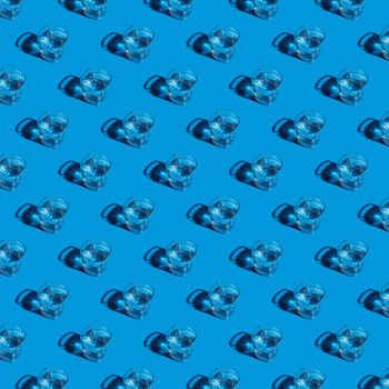 Seamless pattern of glasses with water on a blue background. For printing posters on fabric.
