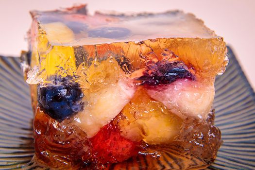 Jelly from different fruits and berries on a square saucer. Dessert. Close-up