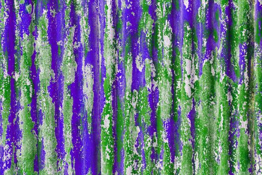 colorful motley peeled off green and purple paint layers on corrugated zinc coated steel sheet - full frame background and texture
