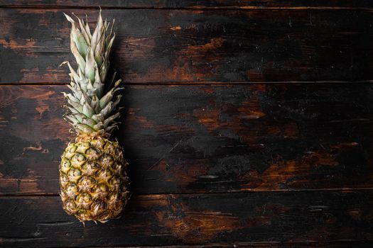 Pineapple tropical fruit set, on old dark wooden table background, top view flat lay, with copy space for text