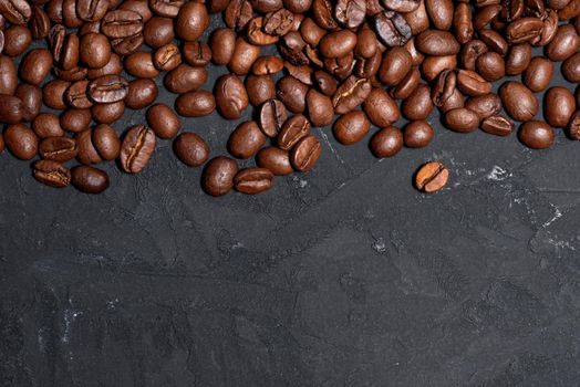 Fresh brown roasted coffee beans on a black table background