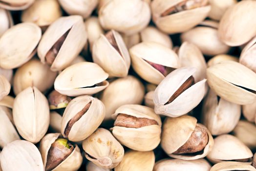 Roasted and salted pistachios in shell background