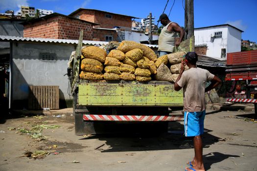 salvador, bahia, brazil - june 28, 2021:People are seen unloading bags of peanuts from a truck at the Sao Joaquim fair in the city of Salvador.

