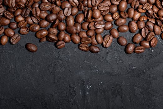 Fresh brown roasted coffee beans on a black board background