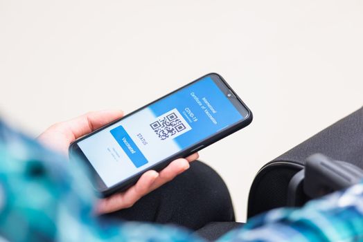 Vaccination passport, Traveler man holding health passport of vaccination certification on smartphone app at airport before boarding plane during coronavirus pandemic, Mobile app of virus COVID-19