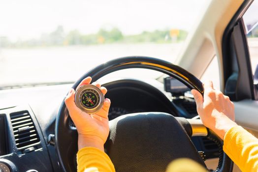 Asian woman inside a car and using compass to navigate while driving the car she find navigation location to go, Transportation and vehicle concept