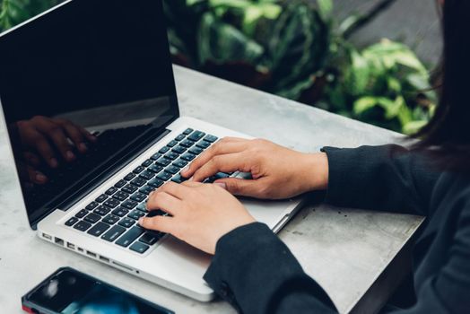 Business woman using his computer laptop on The desk is surrounded by nature