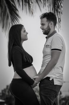 Photo of a young couple with their hands on the belly of the woman who is pregnant