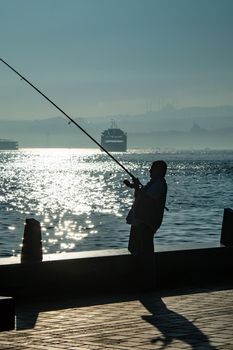 silhouette of man fishing on the seashore