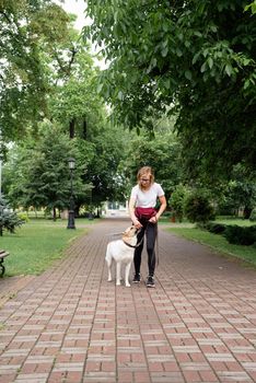 young caucasian woman training her dog in a park. Dog obedience training