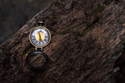 vintage pocket watch on the old wooden background with copy space