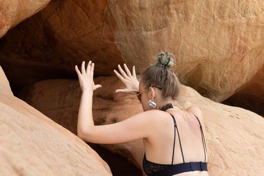 Beauty and healthy lifestyle. Young woman in black lingerie posing near the sandstone caves on the seashore. Shell rock caves.