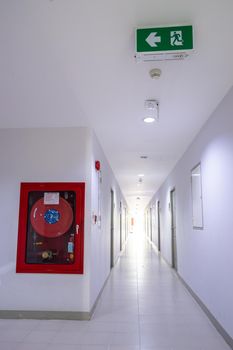 Emergency door escape light sign and fire extinguishers in building