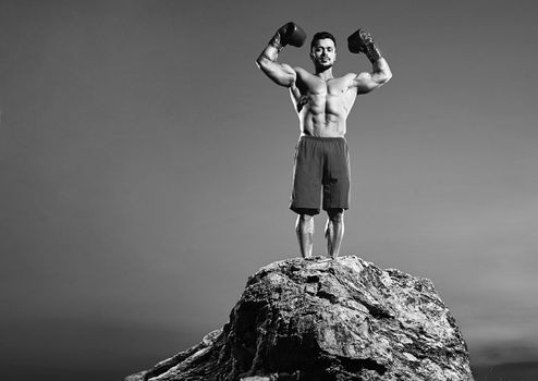 Horizontal full length black and white shot of a strong muscular boxer flexing his muscles posing outdoors copyspace boxing fighter fighting masculinity strength power confidence fitness sport.