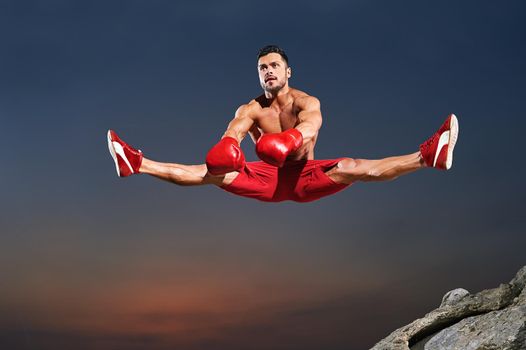 Horizontal shot of a young handsome muscular sportsman doing splits in the air jumping high copyspace gymnast physique sport athletics active lifestyle flexibility stretch fitness motivation endurance.
