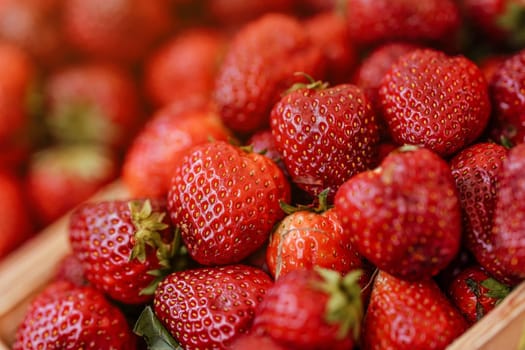 Fresh ripe strawberries displayed on market, closeup detail.