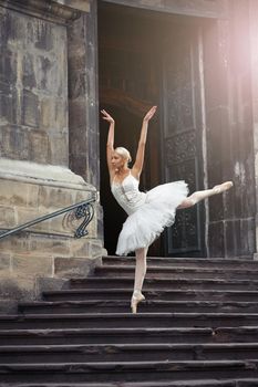 Shot of a graceful blonde haired ballerina dancing on the stairs of an old castle beauty grace elegance concept.