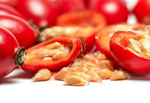 Rosehips Rosa Canina fruits ,cut in half seeds visible macro closeup detail, isolated on white background.