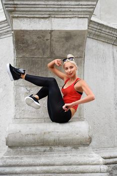 Vertical shot of a beautiful blonde haired young woman having fun outdoors smiling joyfully balance athletic fitness beauty lifestyle.