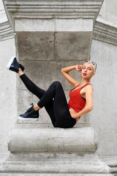 Shot of a gorgeous young blonde woman sitting gracefully resting in the city streets urban fashion style glamour.