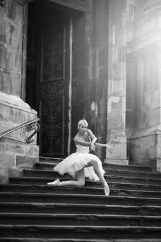Ballet takes dedication. Monochrome vertical portrait of a young ballerina performing outdoors