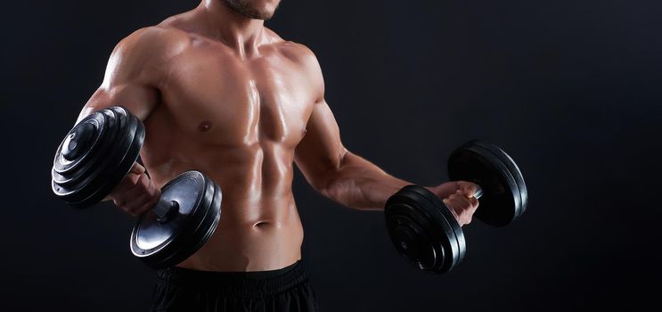 He is on his way. Cropped shot of a fit and toned male posing with dumbbells showing off his biceps copyspace on the side