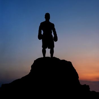 Cropped shot of a silhouette of a muscular ripped male standing on top of a rock stunning sunset scenery on the background goal achievement leadership confidence balance motivation lifestyle people.