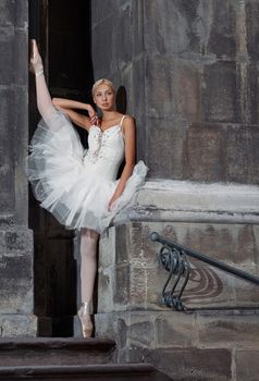 Stretching is everything. Vertical shot of a young ballerina stretching outdoors