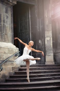 She went looking for inspiration. Full length portrait of a ballerina dancing gracefully near an old house