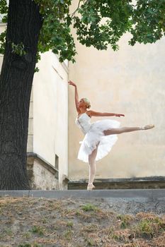 Vertical shot of a young female ballet dancer performing on the streets of the town.
