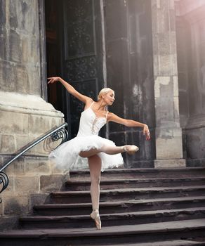 Imagine her performing. Full length shot of a talented ballerina dancing near an old castle