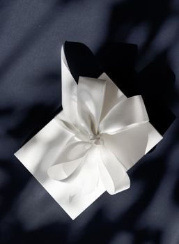 Anniversary celebration, shop sale promotion and luxe surprise concept - Luxury holiday white gift box with silk ribbon and bow on black background, luxe wedding or birthday present