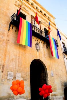 Rainbow flag hanging from the balcony of the town hall for the International Gay Pride Day in Elche, Alicante, Spain.