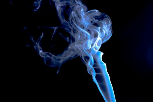 Incense cone shooting beautiful smoke on black background
