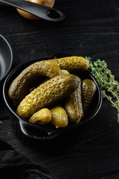 Pickled cucumbers set, on black wooden table background