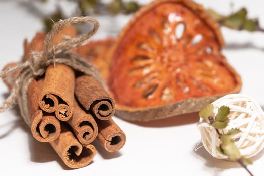 Macro photography of sticks of cinnamon reknitted by twine on a white background with diy rustic decor