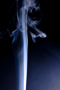 Incense cone shooting beautiful smoke on black background