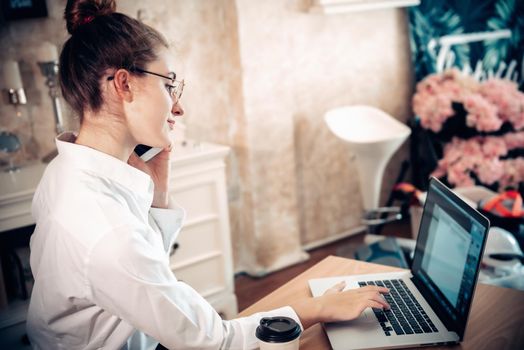 Work From Home Lifestyle and Business Online, Attractive Woman Hands is Calling on Mobile Phone While Working at Home. Business Freelance Person Using Computer Laptop at Her Home Workplace, New Normal