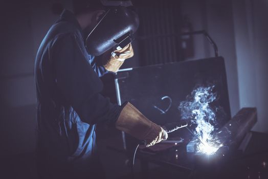 Technical Welder is Working Steel Welding in Assembly Workshop, Welder Structure in Safety Equipment is Welding Metal in Factory Assembling Production Line. Labor Skill and Construction Occupation