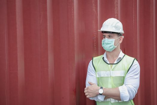 Transport Engineer Man Wearing Medical Face Mask for Prevention Coronavirus Epidemic Situation in Containers Logistic Shipping Yard. Transportation and Logistics after Coronavirus Covid-19 New Normal