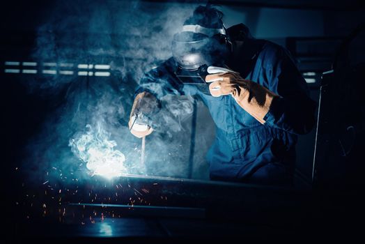 Technical Welder is Working Steel Welding in Assembly Workshop, Welder Structure in Safety Equipment is Welding Metal in Factory Assembling Production Line. Labor Skill and Construction Occupation