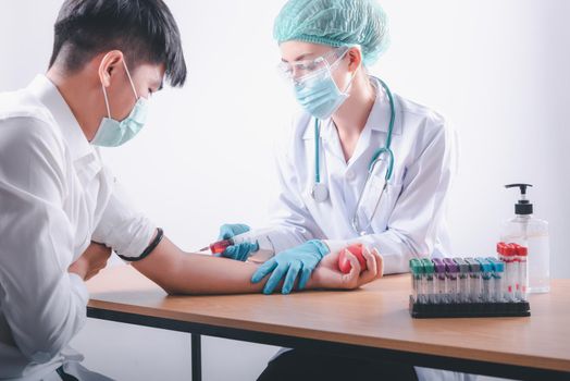 Medical Doctor is Collecting Blood Sample Test Syringe Injection From Male Patient in Laboratory Testing. Female Doctor Taking Patients Blood collection needle for Analysis Disease in Lab. Healthcare