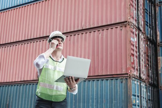 Container Logistics Shipping Management of Transportation Industry, Transport Engineer Managing Control Via Computer Laptop in Containers Shipyard. Business Cargo Ship Import/Export Factory Logistic.